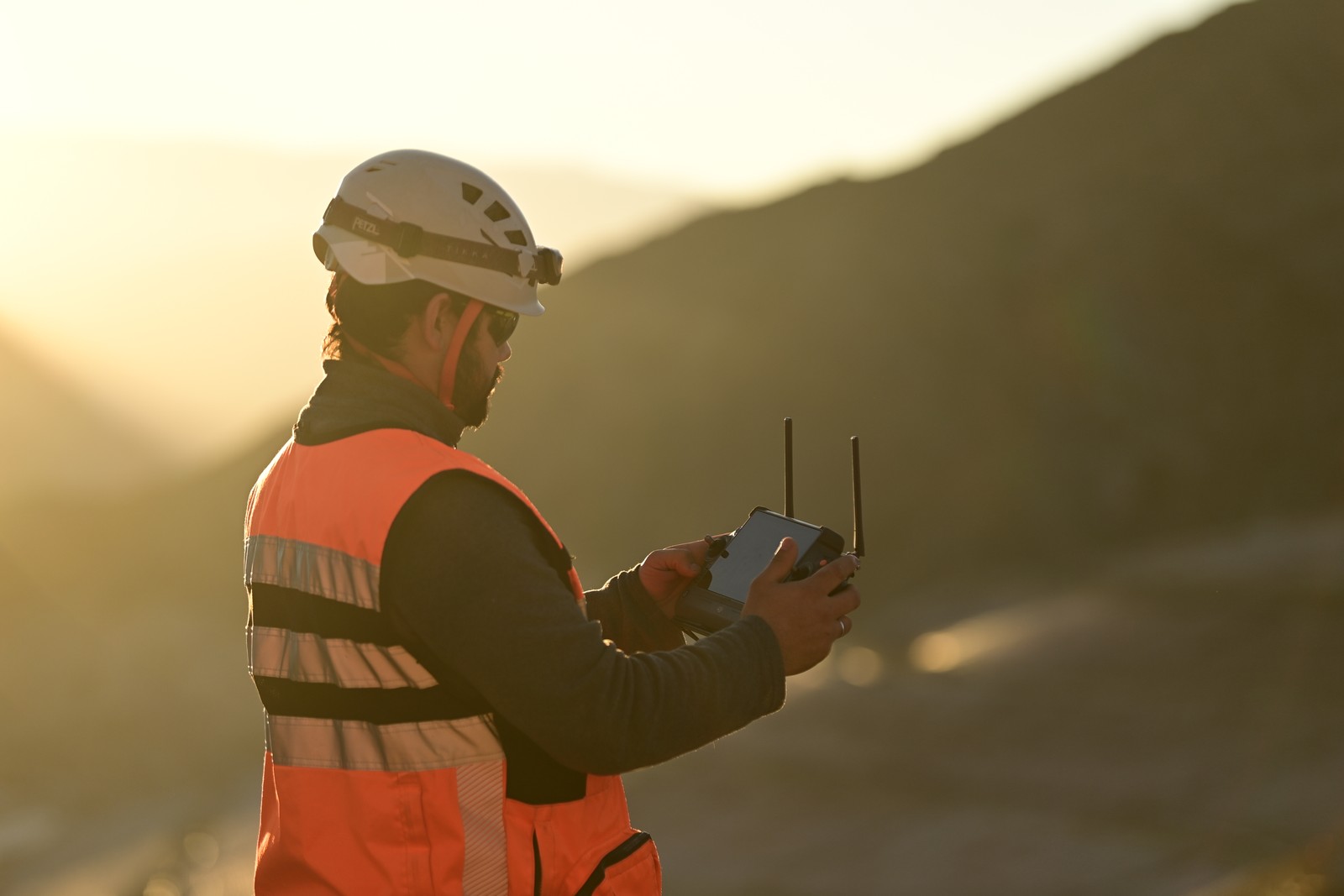 Trabajador de Gualcamayo operando equipamiento al atardecer